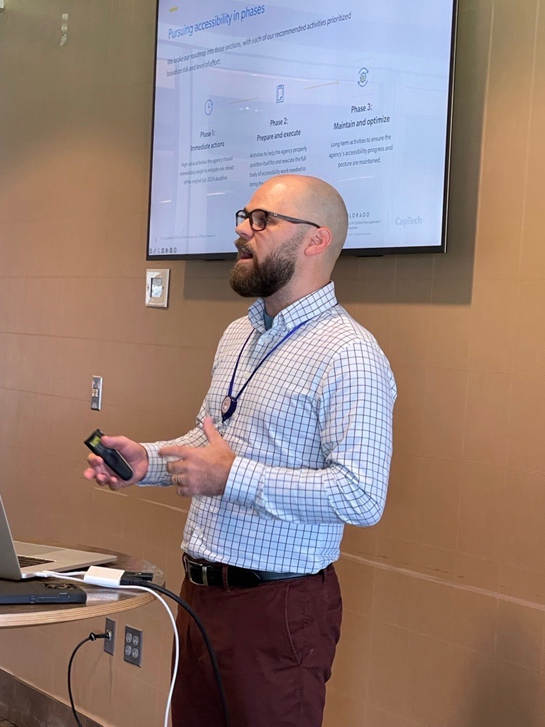Matt Leahy behind a podium, speaking in front of a slide titled Pursuing Accessibility in Phases